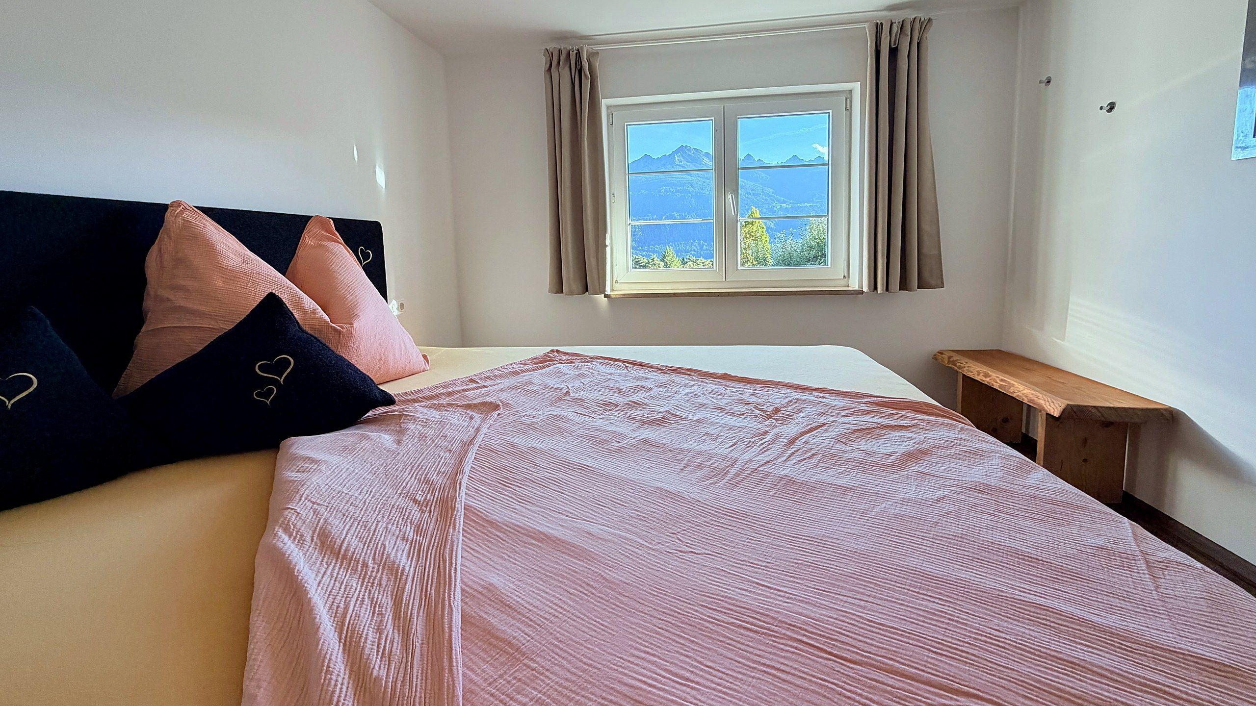 Double bed with a view through the window to the mountains